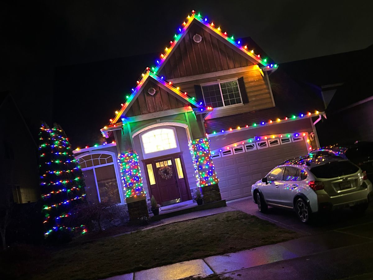 Multicolor Christmas light installation on a two story home