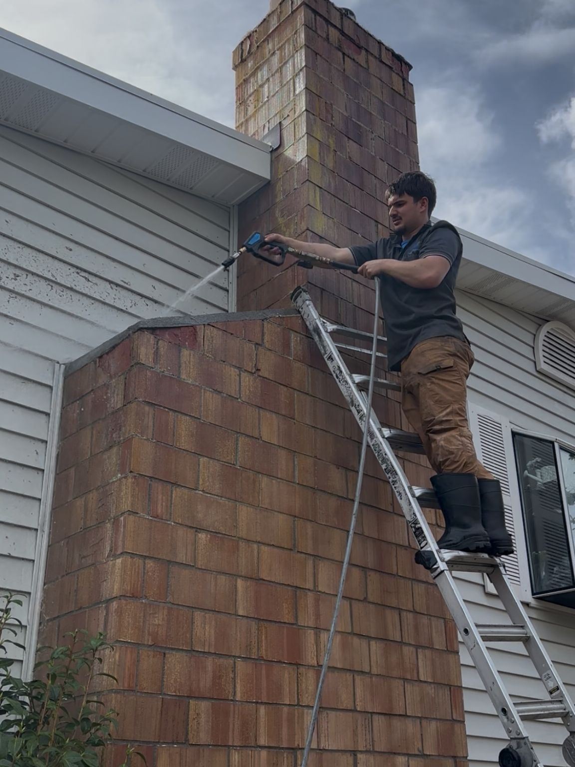 Exterior cleaning in progress on a Pacific Northwest home