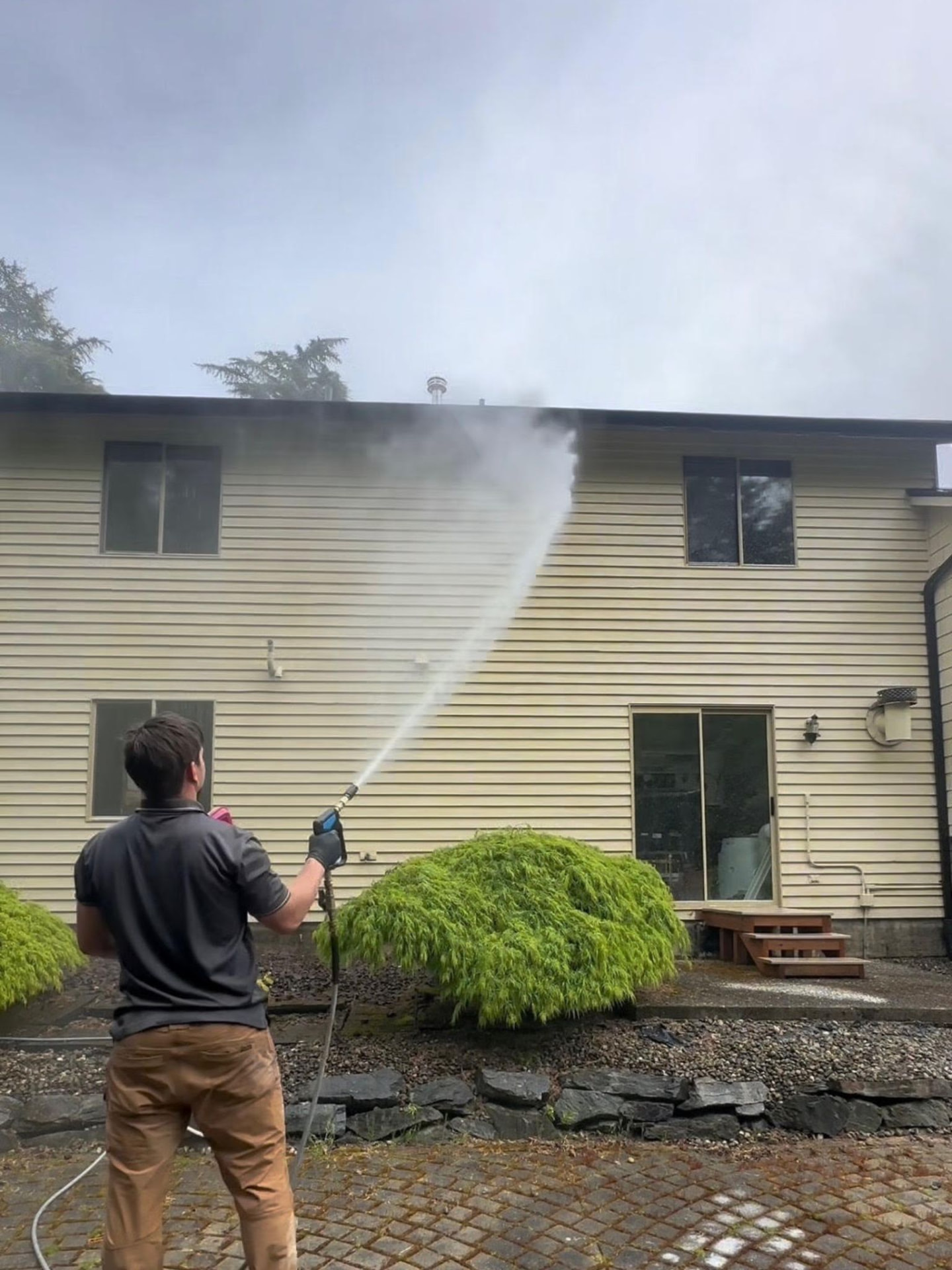 Exterior cleaning in progress on a Pacific Northwest home